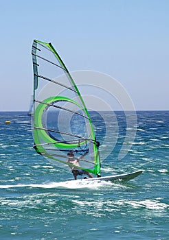 Experienced windsurfer speeding along sunny blue sea giving a real feeling of motion.