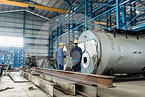 Experienced worker checking the quality of manufactured boilers