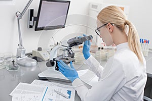 Experienced young lab assistant is doing research
