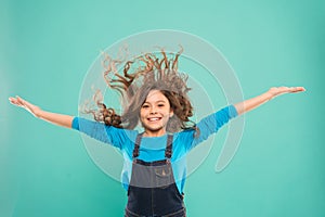 Experiencing a hair to balance your energy. Adorable girl curly hair waving on blue background. Small cute girl with