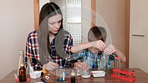 Experiments on chemistry at home. Mother and son do a science experiment together.