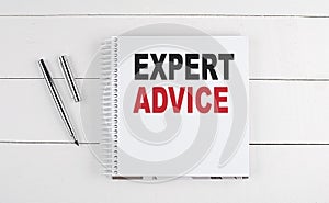 EXPERT ADVICE text written on notebook on the wooden background