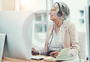 The expert in all things client related. Shot of a happy senior woman working in a call center.