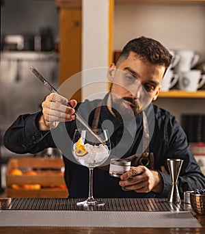 Expert barman is making cocktail