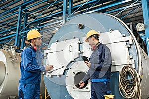 Expert checking the quality of manufactured boilers