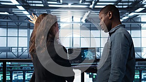 IT expert coding on notebook in server room using artificial intelligence