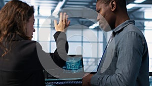 IT expert coding on notebook in server room using artificial intelligence