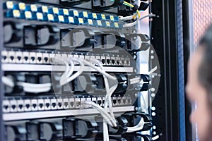 An Expert Engeneer in datacenter server room  connecting cables in server cabinet in network server room