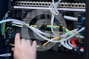 An Expert Engeneer in datacenter server room  connecting cables in server cabinet in network server room