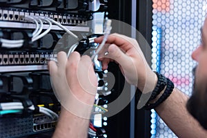 An Expert Engeneer in datacenter server room  connecting cables in server cabinet in network server room