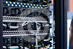 An Expert Engeneer in datacenter server room  connecting cables in server cabinet in network server room