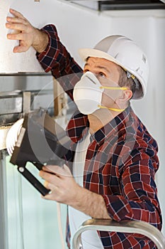 Expert inspecting wall building with lamp