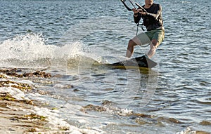 Expert Kitesurfer Planing close to the beach with Pictoresque Sea Watrer Splashes at sunset