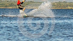 Expert Kitesurfer Planing with  Sea Watrer Splashes during Golden Hour