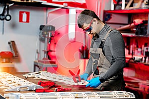 Expert male engineer or technician working on drone details in lab. Aircraft capable of GPS surveillance. Carbon.