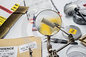 Expert police examines a bullet cap in scientific laboratory with magnifying glass