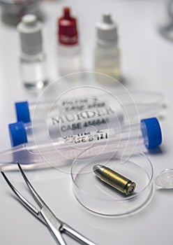 Expert police examines a bullet cap in scientific laboratory with magnifying glass