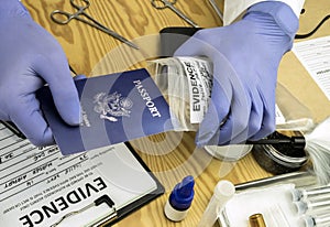 Expert police officer examining American passport of a evidence bag in laboratory of criminology photo