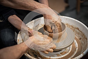 Expert potter teach a man to work on potter wheel