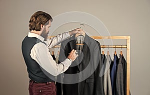 he is an expert tailor. Individual measures hand of man. Man ordering business suit posing indoor. Tailor measures man