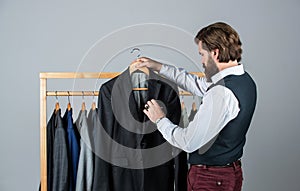 he is an expert tailor. Individual measures hand of man. Man ordering business suit posing indoor. Tailor measures man