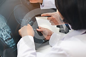 Expertise doctor planning treatment for medical concept. Two asian doctor looking at film x-ray head of patient.