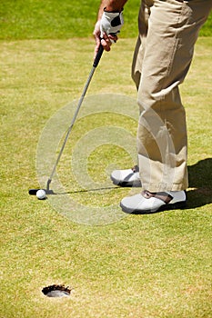 Expertise does it.... A golfer putting on the green.