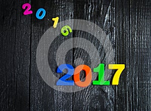 Expiring 2016.New year 2017,colorful figures on the wooden background.