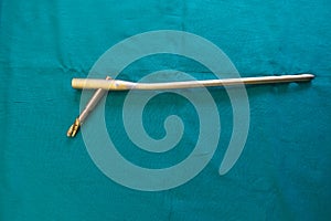 An explanted femoral nail lie spread out on a green surgical drape