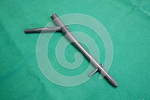 explanted femoral nail lies on a green surgical drape