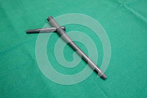 Explanted femoral nail lies on a green surgical drape