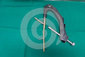 explanted femoral nail with locking screw lies on a green surgical drape