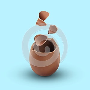 Exploded milk chocolate egg on light blue background