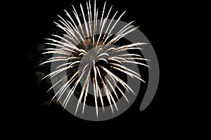 Exploding firework rocket with white stripes, black nightly sky with copy space, silvester midnight photo