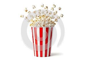 Exploding popcorn in a red and white striped bucket isolated on white background
