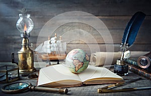 Exploration and nautical theme grunge background. Globe, telescope, divider, old coins, shell, map, book, hourglass, quill pen on