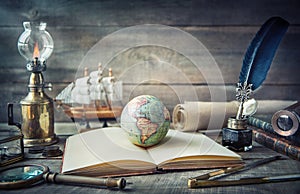 Exploration and nautical theme grunge background. Globe, telescope, divider, old coins, shell, map, book, hourglass, quill pen on