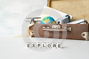 Explore: Adventure Travel Holidays. Travel, adventure, vacation concept. Word EXPLORE and Brown retro suitcase with traveler set o