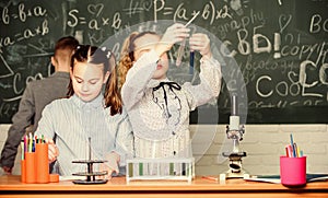 Explore biological molecules. Future technology and science concept. Kids in classroom with microscope and test tubes