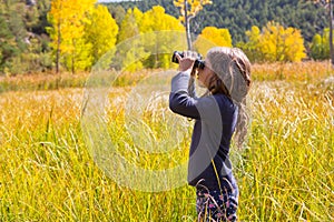 Explorer binocuar kid girl in yellow autumn nature