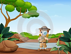 The explorer boy with magnifying glass in the nature