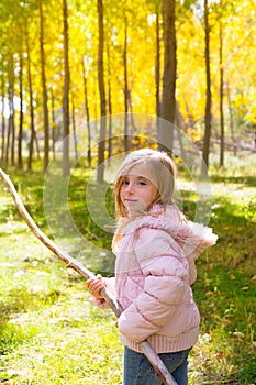 Explorer girl with stick in poplar yellow autumn forest