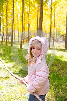 Explorer girl with stick in poplar yellow autumn forest