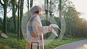 Explorer looking direction map standing roadside at autumn forest. Woman nature