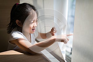 Exploring Concept Illustrated by Asian Child Looking and Pointing Out Window