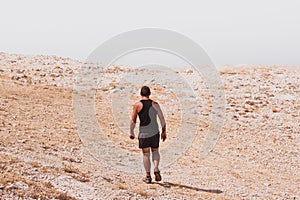 Exploring - lonely human walking in a rocky desert freedom and adventure lifestyle and sport concepts