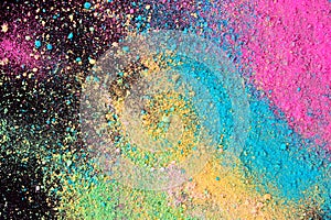 An explosion of colorful pigment powder on black background. Vibrant color dust particles textured background