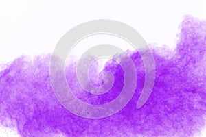 The explosion of violet colored powder. Freeze motion of colored powder exploding on white background.