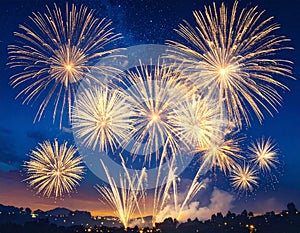 Explosive Fireworks Display Against Dark Blue Sky with Silhouette Trees in Background