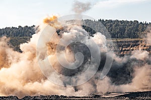 Explosive works on open pit coal mine industry. Dust and puffs of smoke in sky, blasted soil photo